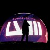 A person is silhouetted against a Super Bowl 58 graphic playing on the Sphere Thursday, Feb. 8, 2024 in Las Vegas. The Kansas City Chiefs will play the NFL football game against the San Francisco 49ers Sunday in Las Vegas. (AP Photo/Charlie Riedel)