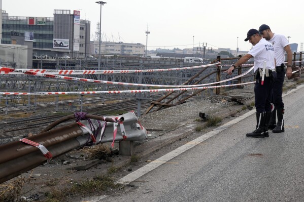 FILE - Local Police officers check the scene of a passenger bus accident in Mestre, near the city of Venice, Italy, Wednesday, Oct. 4, 2023. Prosecutors on Thursday, Oct. 5, 2023 said they have ordered an expert examination of an overpass guardrail that gave way when struck by a shuttle bus that plunged nearly 10 meters, killing 20 foreign tourists and the driver. (AP Photo/Antonio Calanni, File)