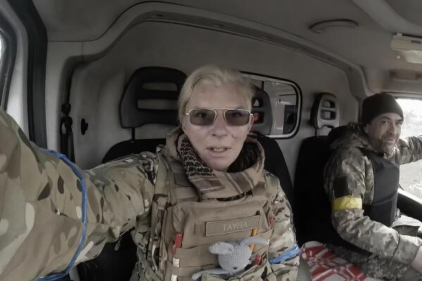 Yuliia Paievska, known as Taira, and her driver Serhiy sit in a vehicle in Mariupol, Ukraine on March 9, 2022. She last appeared on March 21 on Russian television as a captive, handcuffed and with bruises on her face. Using a body camera, she recorded her team's frantic efforts to bring people back from the brink of death. (Yuliia Paievska via AP)
