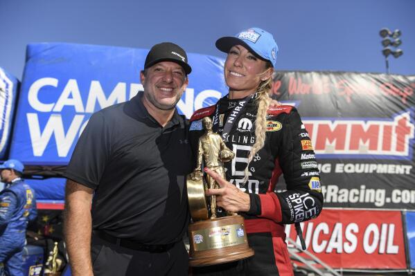 In this photo provided by the NHRA, Top Fuel driver Leah Pruett celebrates her Auto Club Raceway at Pomona auto race win with fiancé Tony Stewart, Sunday, Aug. 1, 2021, in Pomona, Calif. Pruett took home her first title of the season on Sunday when she cruised to a 4.021-second lap at 247.61 mph in her Sparkling Ice Spiked Top Fuel dragster. (Jerry Foss/NHRA via AP)