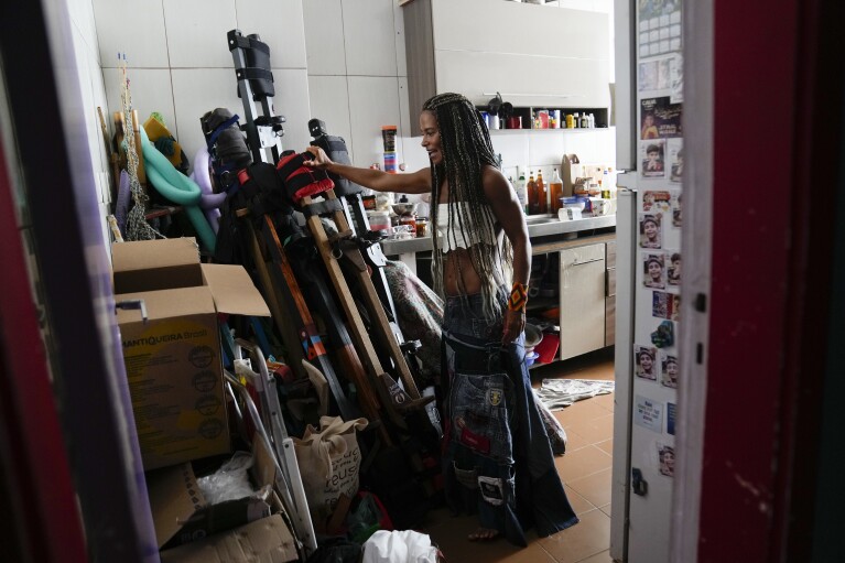 Raquel Pot铆 shows her collection of wooden stilts stored in the kitchen of her home, during an interview, in Rio de Janeiro, Brazil, Saturday, Jan. 27, 2024. At just over 5 feet tall, Pot铆 is chiefly responsible for the explosion of stilt walking in Rio, having trained more than 1,000 kids and adults over the past decade. (AP Photo/Silvia Izquierdo)