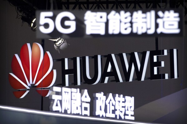 FILE - In this Sept. 26, 2018, file photo, signs promoting 5G wireless technology from Chinese technology firm Huawei are displayed at the PT Expo in Beijing. Germany's top security official says the country will bar the use of components made by Chinese companies Huawei and ZTE from core parts of its 5G networks, in two steps starting in 2026. Germany, which has Europe’s biggest economy, (AP Photo/Mark Schiefelbein, File)