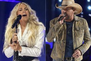 Carrie Underwood performs at the CMT Music Awards in Nashville, Tenn., on May 5, 2021, left, and  Jason Aldean performs at the 54th annual Academy of Country Music Awards in Las Vegas on April 7, 2019. Underwood and Aldean will perform together at the CMA Awards on Nov. 10. (AP Photo)