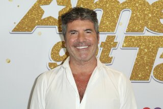 FILE - In this Sept. 18, 2018, file photo, Simon Cowell arrives at the "America's Got Talent" Season 13 Finale Show red carpet at the Dolby Theatre, in Los Angeles. “America's Got Talent” topped the ratings last week, but it faces the absence of Cowell, seriously injured in an electric bicycle accident. Cowell, the NBC talent contest's creator and linchpin of its judging panel, underwent surgery for a broken back last Saturday, Aug. 8, 2020, just before the show kicked off its live episodes this week. (Photo by Willy Sanjuan/Invision/AP, File)