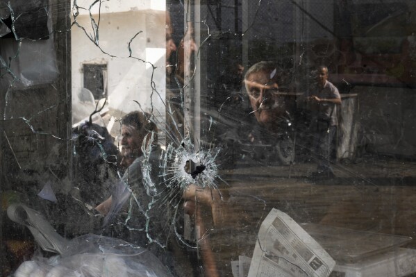 A bullet hole is seen in a shop window following an Israeli military raid in the Jenin refugee camp, West Bank, Wednesday, Sept. 20, 2023. Palestinian health officials say the death toll over a day of fighting between Israel and the Palestinians in the occupied West Bank and the Gaza Strip has risen to six, four from Jenin. The army said that forces carried out a rare strike Tuesday with a suicide drone during the operation and exchanged fire with gunmen in Jenin. (AP Photo/Majdi Mohammed)