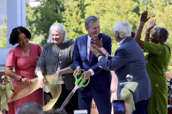 Gov. Roy Cooper, center, joins leaders from the state Department of Natural and Cultural Resources and the state African American Heritage Commission for a ribbon cutting ceremony at North Carolina Freedom Park in Raleigh, N.C., Wednesday, Aug. 23, 2023. (AP Photo/Hannah Schoenbaum)