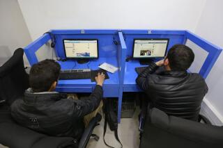 In this Feb. 10, 2016 photo, Afghanis access social media websites at a private internet cafe in Kabul, Afghanistan. As the Taliban negotiates with senior politicians and government leaders following its lightning-fast takeover of Afghanistan, U.S. social media companies are reckoning with how to deal with a violent extremist group that is poised to rule a country of 40 million people. (AP Photo/Rahmat Gul)