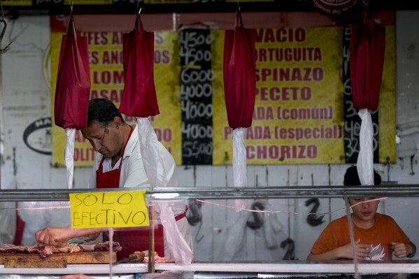Un carnicero corta carne en un mercado en las afueras de Buenos Aires, Argentina, el miércoles 10 de enero de 2024. (Foto AP/Natacha Pisarenko)