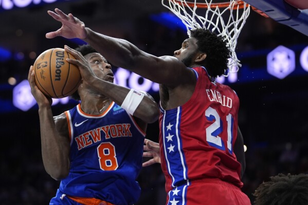 New York Knicks' OG Anunoby, left, tries to get a shot past Philadelphia 76ers' Joel Embiid during the first half of an NBA basketball game, Friday, Jan. 5, 2024, in Philadelphia. (AP Photo/Matt Slocum)