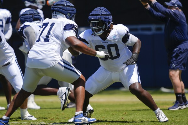 Dallas Cowboys offensive tackle Tyler Guyton, right, and guard Chuma Edoga run drills during NFL football training camp, Tuesday, July 30, 2024, in Oxnard, Calif. (AP Photo/Ryan Sun)