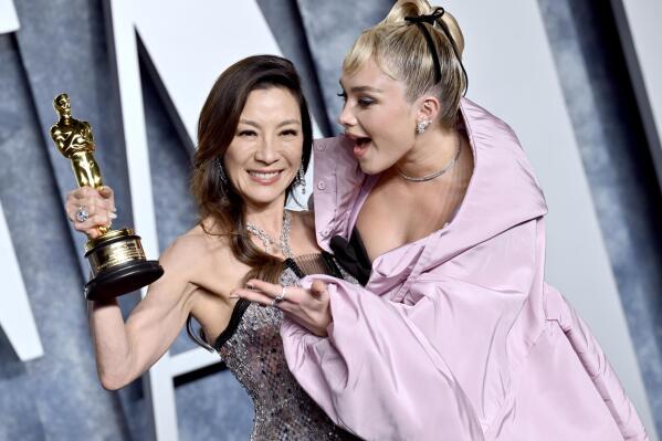 Michelle Yeoh, left, winner of the Oscar for lead actress, and Florence Pugh arrive at the Vanity Fair Oscar Party on Sunday, March 12, 2023, at the Wallis Annenberg Center for the Performing Arts in Beverly Hills, Calif. (Photo by Evan Agostini/Invision/AP)