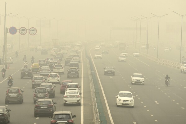 Traffic moves on a road enveloped by fog and smog in New Delhi, India, Friday, Nov. 3, 2023. Authorities on Friday shut primary schools and banned polluting vehicles and construction activity to control the worst haze and smog this season, causing respiratory infections among people and enveloping monuments and high-rise buildings in and around New Delhi. (AP Photo)