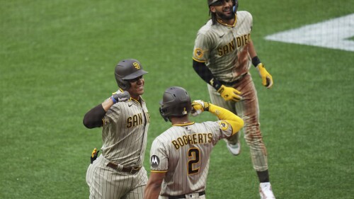 Juan Soto des San Diego Padres, à gauche, célèbre son coup de circuit de deux points contre les Blue Jays de Toronto avec Xander Bogaerts (2) et Fernando Tatis Jr. lors de la première manche d'un match de baseball le mardi 18 juillet 2023 à Toronto.  (Chris Young/La Presse canadienne via AP)