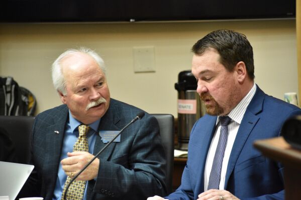 Montana Democratic Minority Leader Sen. Pat Flowers, left, speaks with Republican Sen. Josh Kassmier during a committee meeting at the state Capitol, April 16, 2025, in Helena, Mont. (AP Photo/Matthew Brown)