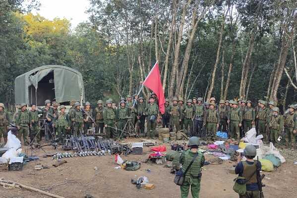 Members of the Myanmar National Democratic Alliance Army pose for a photograph with the weapons allegedly seized from the Myanmar's army outpost on a hill in Chinshwehaw town, Myanmar, Saturday Oct. 28, 2023. The leader of Myanmar’s army-installed government said the military will carry out counter-attacks against a powerful alliance of ethnic armed groups that has seized towns near the Chinese border in the country’s northeastern and northern regions, state-run media reported Friday Nov. 3, 2023. ("The Kokang" online media via AP)