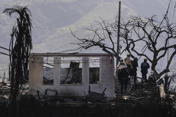 Search and rescue team members work in a residential area devastated by a wildfire in Lahaina, Hawaii, Aug. 18, 2023. (AP Photo/Jae C. Hong)