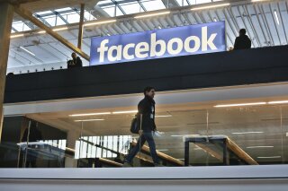 FILE - In this Jan.17, 2017 file photo, the Facebook logo is displayed in a start-up companies gathering at Paris' Station F, in Paris. France's lower house of parliament has approved a pioneering tax on internet giants like Google, Amazon and Facebook. The bill adopted Thursday by the National Assembly aims to stop multinationals from avoiding taxes by setting up headquarters in low-tax EU countries. (AP Photo/Thibault Camus, File)