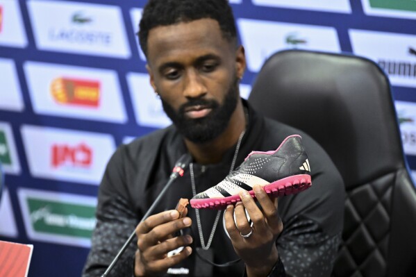 Israel team captain Eli Dasa shows a shoe of a kidnapped Israeli boy during a press conference, before a training session for the Euro 2024 group I qualifying soccer match between Israel and Switzerland at the Pancho Arena in Felcsút, Hungary, Tuesday, Nov. 14, 2023. The captain of Israel's soccer team on Tuesday displayed the shoe of a young boy that he said was kidnapped by Hamas militants during their deadly Oct. 7 raid, an act of solidarity with those Israelis still being held captive in the Gaza Strip ahead of the team's Wednesday game in Hungary. (AP Photo/Denes Erdos)
