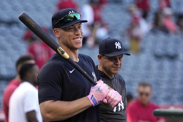 New York Yankees' Aaron Judge, left, smiles during batting practice as manager Aaron Boone stands by prior to a baseball game against the Los Angeles Angels Tuesday, July 18, 2023, in Anaheim, Calif. (AP Photo/Mark J. Terrill)