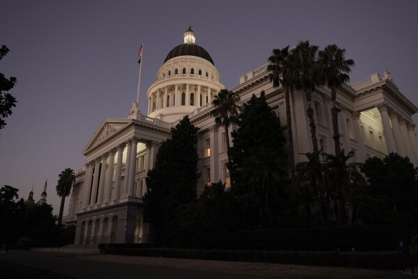 FILE - The lights of the state Capitol glow into the night in Sacramento, Calif., Aug. 31, 2022. A new California law that takes effect April 2024 requires a $20 minimum wage for fast food workers. Negotiations over that law concluded last fall and reflect the reality of public policy making in the United States. (AP Photo/Rich Pedroncelli, File)