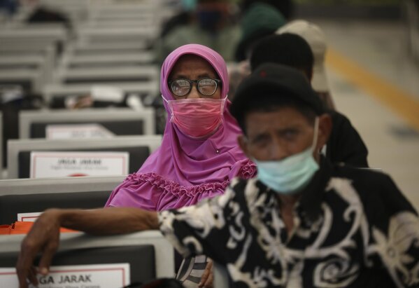 People wearing face masks sit spaced apart as a social distancing effort to help curb the spread of the coronavirus in a train station's waiting area, Tuesday, April 7, 2020, in Jakarta, Indonesia. The new coronavirus causes mild or moderate symptoms for most people, but for some, especially older adults and people with existing health problems, it can cause more severe illness or death. (AP Photo/Dita Alangkara)