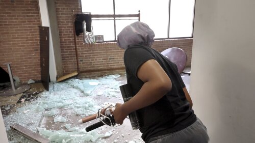 FILE - Hairstylist Bunnei Johnson checks out the scene on the fifth floor of a building at 1409 Washington Ave., where 10 teens were shot overnight, one fatally, during a party in the building in downtown St. Louis, June 18, 2023. A former judge, state lawmaker and criminologist on Wednesday, June 29, filed initiative petitions that would amend Missouri's Constitution to allow St. Louis and other local governments to adopt their own gun policies. (David Carson/St. Louis Post-Dispatch via AP, File)