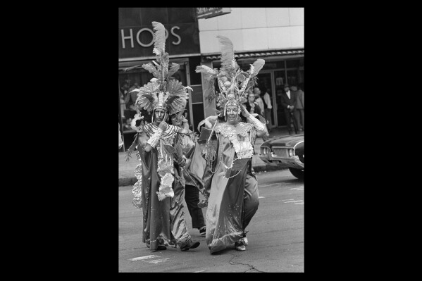 Marti and Rochelle Martin hold on to their flashy headgear as they cross Canal Street in New Orleans on a windy damp day, March 6, 1973. The Inca costumes, which aren't anything unusual on Mardi Gras were designed and made by the Martins for less than $40. (AP Photo, file)