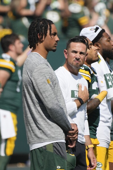 Injured Green Bay Packers quarterback Jordan Love, left, stands with head coach Matt LaFleur for the Natioanl Anthem before the start of an NFL football game against the Indianapolis Colts Sunday, Sept. 15, 2024, in Green Bay, Wis. (AP Photo/Morry Gash)