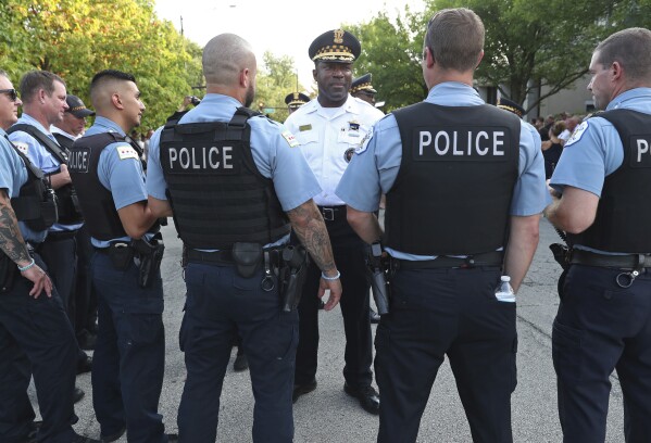 Deputy Chief Larry Snelling, center, talks with officers before a prayer service in memory of Officer Ella French outside the 22nd District, 1900 W. Monterey Ave., on Aug. 11, 2021, in Chicago. Chicago Mayor Brandon Johnson on Sunday, Aug. 13, 2023, named Snelling, the police department's counterterrorism head, as his choice for police superintendent of the nation's third-largest city. (John J. Kim/Chicago Sun-Times via AP)