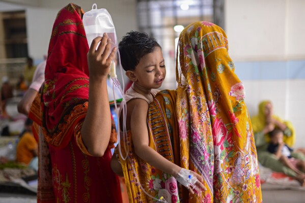 Seorang anak digendong oleh ibunya saat menerima perawatan demam berdarah di Mugda Medical College and Hospital di Dhaka, Bangladesh, Kamis, 10 Agustus 2023.  (AP Photo/Mahmud Hossain Opu)