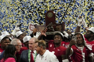 Alabama quarterback Jalen Milroe (4) center and the team holds up the championship trophy after the Southeastern Conference championship NCAA college football game against Georgia in Atlanta, Saturday, Dec. 2, 2023. (AP Photo/John Bazemore)