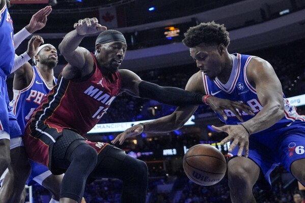 Miami Heat's Bam Adebayo (13) and Philadelphia 76ers' Kyle Lowry, right, vie for the ball during the second half of an NBA basketball game, Monday, March 18, 2024, in Philadelphia. (AP Photo/Matt Rourke)