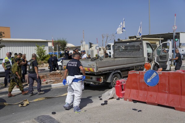Israeli security forces inspect the scene of a Palestinian ramming attack near West Bank Maccabim checkpoint, Thursday, Aug. 31, 2023. A Palestinian driver slammed his truck into pedestrians at a busy checkpoint in the occupied West Bank on Thursday, killing one Israeli before being shot, Israeli authorities said. (AP Photo/Ohad Zwigenberg)