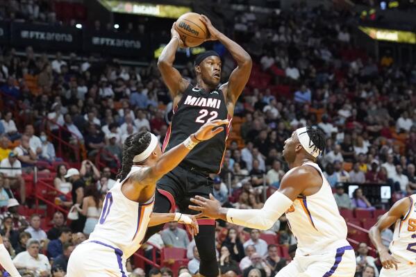 Miami Heat forward Jimmy Butler (22) aims to pass the ball as Phoenix Suns guard Damion Lee (10) and forward Josh Okogie (2) defend during the first half of an NBA basketball game Monday, Nov. 14, 2022, in Miami. (AP Photo/Marta Lavandier)