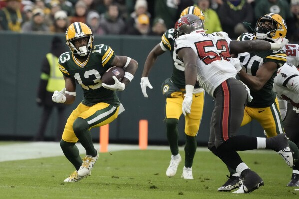 Green Bay Packers wide receiver Dontayvion Wicks (13) catches a pass for a first down during the second half of an NFL football game against the Tampa Bay Buccaneers, Sunday, Dec. 17, 2023, in Green Bay, Wis. (AP Photo/Morry Gash)