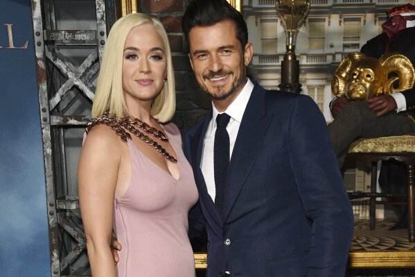 FILE - This Aug. 21, 2019 file photo shows Orlando Bloom, right, a cast member in the Amazon Prime Video series "Carnival Row," with singer Katy Perry, at the premiere of the series in Los Angeles. Perry has revealed she's pregnant at the end of the video for her latest song “Never Worn White.” The news was confirmed Thursday by Perry's label, Capitol Music Group. The baby will be Perry's first, and the second for her fiance, Orlando Bloom, who has a 9-year-old son, Flynn, with ex-wife Miranda Kerr. (Photo by Chris Pizzello/Invision/AP, File)