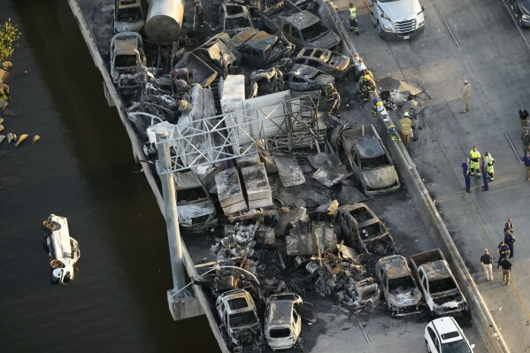 FILE - In this aerial photo, responders are seen near wreckage in the aftermath of a multi-vehicle pileup on Interstate 55 in Manchac, La., Oct. 23, 2023. A Louisiana truck driver has been charged with negligent homicide for his role in the fiery highway pileup that left eight dead after a “super fog” of marsh fire smoke and dense fog snared more than 160 vehicles, authorities said. (AP Photo/Gerald Herbert, File)