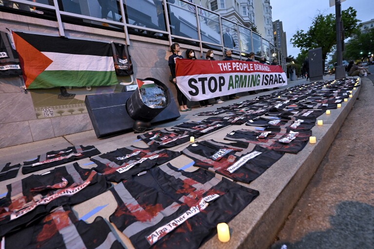 Demonstranci trzymają znak i rozprowadzają czerwoną farbę na podłodze podczas propalestyńskiej demonstracji przeciwko wojnie Izrael-Hamas podczas kolacji Stowarzyszenia Korespondentów Białego Domu w Waszyngtonie, sobota, 27 kwietnia 2024 r.  (AP Photo/Terrence Williams)