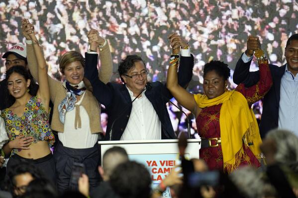 Presidential candidate Gustavo Petro, center, and his running mate Francia Marquez, at his right, with the Historical Pact coalition, stand before supporters with Marquez's wife Veronica Alcocer, second from left, and their daughter Andrea on election night in Bogota, Colombia, Sunday, May 29, 2022. Petro will advance to a runoff contest in June after none of the six candidates in Sunday's first round got half the vote. (AP Photo/Fernando Vergara)