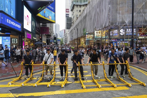 Police officers set road blocker on the street in the Causeway Bay area on the 36th anniversary of China's Tiananmen Square crackdown, in Hong Kong, Wednesday, June 4, 2025. (AP Photo/Chan Long Hei)