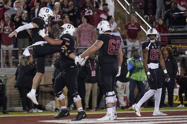 Stanford quarterback Justin Lamson, left, is congratulated by teammates after scoring against Washington during the second half of an NCAA college football game in Stanford, Calif., Saturday, Oct. 28, 2023. (AP Photo/Jeff Chiu)