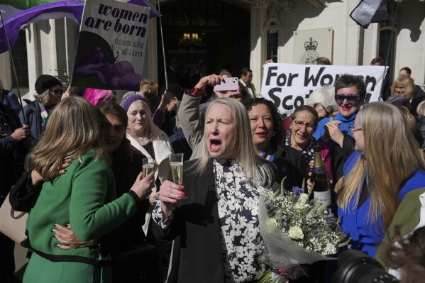 Marion Calder, ở giữa, và Susan Smith, bên trái, từ For Women Scotland, ăn mừng bên ngoài sau khi Tòa án Tối cao Vương quốc Anh phán quyết rằng phụ nữ là người sinh ra là nữ về mặt sinh học, loại trừ người chuyển giới khỏi định nghĩa pháp lý trong một cuộc tranh chấp kéo dài giữa nhóm nữ quyền và chính quyền Scotland, tại London, thứ Tư, ngày 16 tháng 4 năm 2025. (Ảnh AP/Kin Cheung)