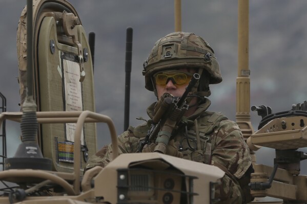 FILE - A British soldier with NATO-led Resolute Support Mission forces arrives at the site of an attack in Kabul, Afghanistan, Wednesday, March 25, 2020. The U.K. government said Wednesday it has no plans to introduce conscription, after the head of the British Army said a “citizen army” would be needed to fight a future war with a country like Russia. (AP Photo/Rahmat Gul, File)