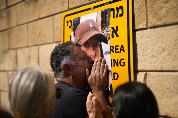Eli Albag cries over the photograph of his daughter Liri during a protest demanding the release of dozens of Israelis who were abducted during last week's unprecedented Hamas attack, in Tel Aviv, Israel, Saturday, Oct. 14, 2023. (AP Photo/Francisco Seco)