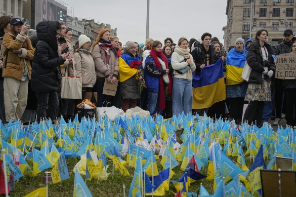 People stand at the memorial site for those killed during the war, near Maidan Square in central Kyiv, Ukraine, Saturday, Feb. 24, 2024. Ukraine is marking two years since Russia's full-scale invasion with a somber mood hanging over the country. On the battlefield, Ukrainian troops are running low on ammunition as they hope for further Western aid. (AP Photo/Efrem Lukatsky)