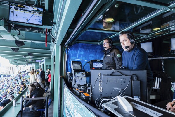 In this photo provided by TNT Sports, Kenny Albert, right, calls the Winter Classic between the Pittsburgh Penguins and Boston Bruins at Fenway Park in Boston, Jan. 2, 2023. Albert will be calling his third Stanley Cup Final on television when the Florida Panthers face the Edmonton Oilers on Wednesday, June 4, 2025. (John Nowak/TNT Sports via AP)