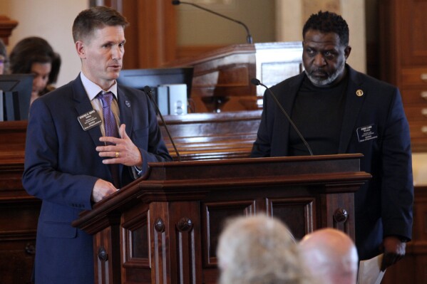 Kansas state Rep. Steve Howe, left, R-Salina, answers questions from Rep. Ford Carr, right, D-Wichita, during a House debate on a bill designed to restrict diversity, equity and inclusion initiatives on university campuses, Wednesday, March 20, 2024, at the Statehouse in Topeka, Kan. Howe backs the bill, which would bar universities from requiring prospective students, job applicants or employees to make statement for or against any "ideology or movement," including DEI. (AP Photo/John Hanna)