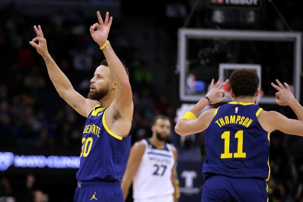 Golden State Warriors guard Stephen Curry (30) celebrates a basket by guard Klay Thompson (11) as Minnesota Timberwolves center Rudy Gobert (27) watches during the fourth quarter of an NBA basketball game Sunday, Nov. 27, 2022, in Minneapolis. (AP Photo/Andy Clayton-King)