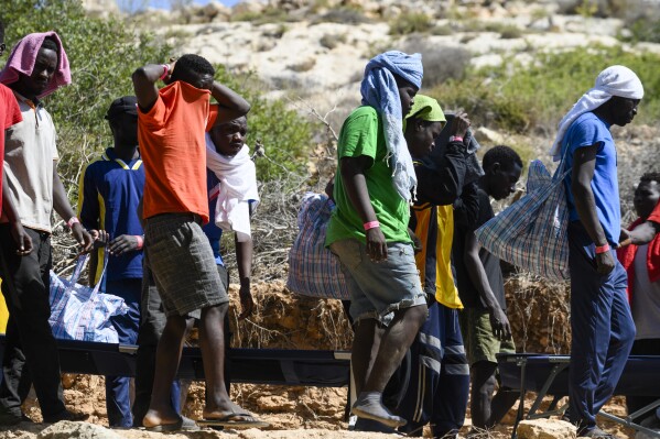 FILE - Migrants walk in Lampedusa Island, Italy, Friday, Sept. 15, 2023. Europeans focus more on curbing immigration than on climate change and less than 15% of those interviewed across the globe consider climate change to be among the top three priorities for their government, a global study revealed on Wednesday.(AP Photo/Valeria Ferraro, File)