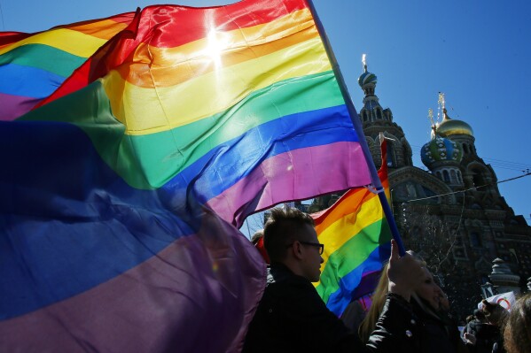 FILE - Gay rights activists carry rainbow flags as they march during a May Day rally in St. Petersburg, Russia, Wednesday, May 1, 2013. Russia’s Supreme Court on Thursday, Nov. 30, 2023, effectively outlawed LGBTQ+ activism, in the most drastic step against advocates of gay, lesbian and transgender rights in the increasingly conservative country. (AP Photo, File)